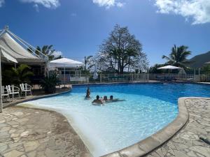 un grupo de personas en una piscina en Studio spacieux vue mer au DIAMANT avec piscine, en Le Diamant 5 fotos más