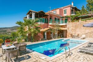 a villa with a swimming pool and a house at Villa Sandy in Syvota