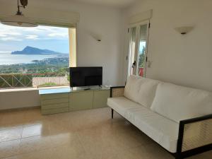 sala de estar con sofá blanco y TV en Spacious villa in Altea Hills, en Altea