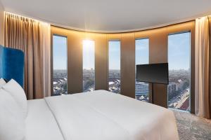 um quarto com uma cama grande e uma janela grande em HYPERION Hotel München em Munique