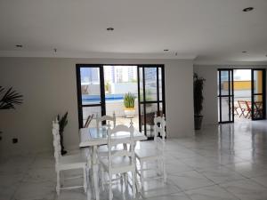 a white dining room with a table and white chairs at Via Venetto Flat Fortaleza Bera mar Meireles in Fortaleza