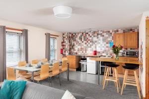 a kitchen and living room with a table and chairs at Discovery Accommodation in Whitby