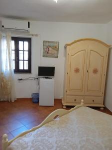 a bedroom with a bed and a cabinet and a window at B&B Baia Turchese in Porto Ottiolu