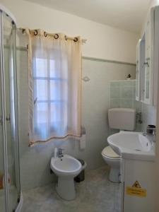 een badkamer met een wastafel, een toilet en een douche bij B&B Baia Turchese in Porto Ottiolu