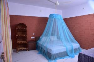 - un lit doté d'une moustiquaire bleue dans l'établissement Doctors Ayurveda Heritage, à Varkala 18 autres photos