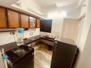 Una cocina con un refrigerador negro y un fregadero. en Andoor Homes, Apt No 3B, en Trivandrum