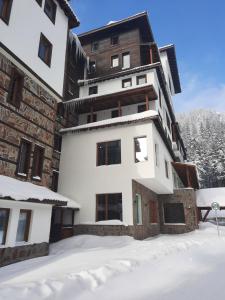a building with snow in front of it at Apartment Svetoslava in Pamporovo