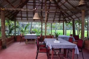 een eetkamer met tafels en stoelen in een paviljoen bij Doctors Ayurveda Heritage in Varkala