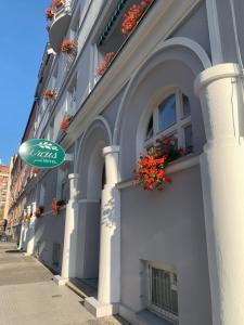 a building with a green sign on the side of it at Hotel Arcus Garden in Bratislava