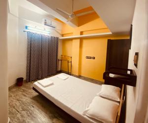 Habitación pequeña con cama y cortina en Andoor Homes, Apt No 3B, en Trivandrum