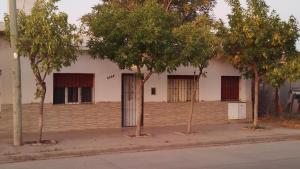 a white building with trees in front of it at Floma in Neuquén