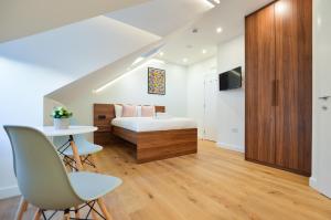 een slaapkamer met een bed en een tafel en stoelen bij West Hampstead Serviced Apartments by Concept Apartments in Londen