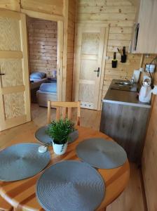 a kitchen with a table with four plates on it at Domki nad morzem Jula in Wrzosowo