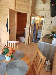 a wooden cabin with a table and a kitchen at Domki nad morzem Jula in Wrzosowo