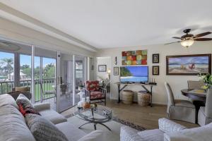 a living room with a couch and a tv at Island-style condo with pool, spa and steps to beach in Marco Island