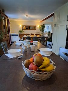 una mesa con una cesta de fruta. en A Vellereux houffalize, en Houffalize