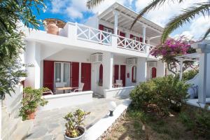 Cette maison blanche dispose de portes rouges et d'une terrasse. dans l'établissement Domna Hotel, à Mykonos