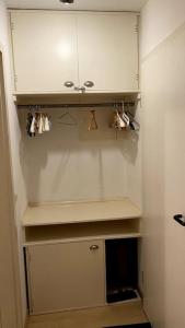 a kitchen with white cabinets and mugs on a shelf at Appartment mit großem Balkon im belgischen Viertel in Cologne