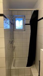 a shower with a black shower curtain in a bathroom at Appartment mit großem Balkon im belgischen Viertel in Cologne