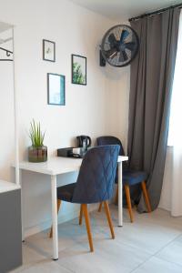 a desk with two chairs and a table with a clock at Espenlaub in Stuttgart