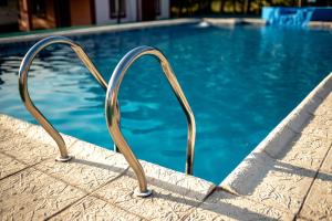 a swimming pool with a metal heart shaped pool railing at Cabañas y Posada La Vertiente in Los Reartes