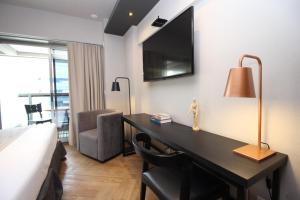 a hotel room with a desk with a bed and a television at 360 República in Sao Paulo