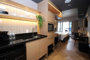 a kitchen with a sink and a room with a bed at 360 República in Sao Paulo