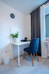a white desk with a blue chair in a room at Espenlaub in Stuttgart