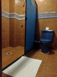 a bathroom with a blue toilet and a shower at Mi Depa Cascada in Ciudad Valles