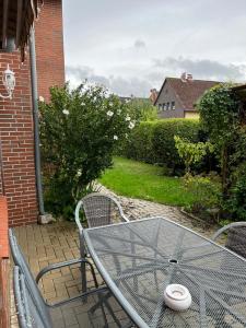 a glass table and chairs on a patio at Wohnung nahe Heidepark & Serengetipark in Bergen