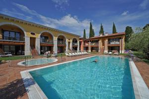 una gran piscina frente a un edificio en Appartamenti Corte Leonardo, en Garda
