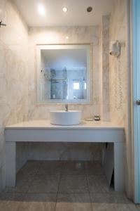 y baño con lavabo y espejo. en Domna Hotel, en Mykonos ciudad