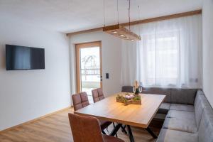 a dining room with a table and a couch at Apartment Hoflacher in Schwendau
