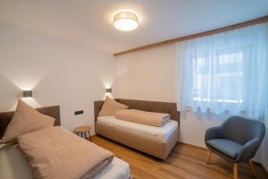Habitación con cama, silla y ventana en Apartment Hoflacher en Schwendau