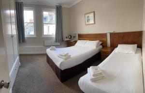 um quarto de hotel com duas camas e uma janela em Clarence House Hotel em Tenby