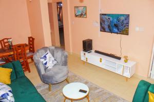 a living room with a couch and a tv at Royal Palms Executive 2& 1 bedrooms BNB Wote town in Wote