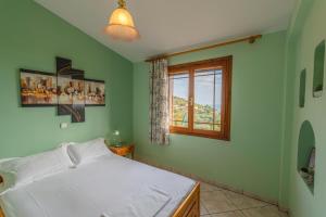 a bedroom with a white bed and a window at Villa Melina 2 in Koinyra