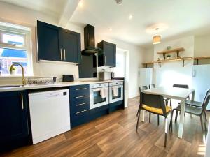 a kitchen with a table and a dining room at Spacious 3 Bedroom House - 5 Minutes to the nearest Beach! - Great Location - Garden - Parking - Fast WiFi - Smart TV - Newly decorated - sleeps up to 7! Close to Poole & Bournemouth & Sandbanks in Lytchett Minster +18 photos