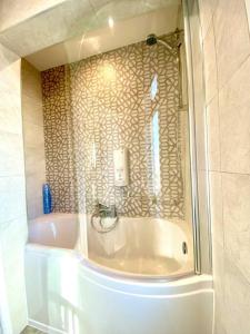 a bath tub in a bathroom with a glass window at Spacious 3 Bedroom House - 5 Minutes to the nearest Beach! - Great Location - Garden - Parking - Fast WiFi - Smart TV - Newly decorated - sleeps up to 7! Close to Poole & Bournemouth & Sandbanks in Lytchett Minster
