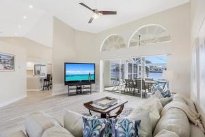 Una sala de estar con un sofá y un televisor. en Waterfront home with spectacular view, pool and spa, en Marco Island