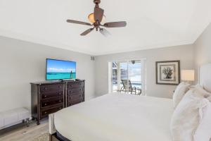 1 dormitorio con 1 cama con ventilador de techo y TV en Waterfront home with spectacular view, pool and spa, en Marco Island 20 fotos más