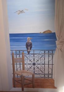 un oiseau assis sur la balustrade d'un balcon dans l'établissement Hotel Ristorante Moderno, à SantʼAntìoco