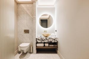 a bathroom with a sink and a toilet and a mirror at Hotel 717 in Amsterdam