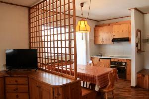 a kitchen with a table and a television in a room at Residence Casa Cavalese in Cavalese