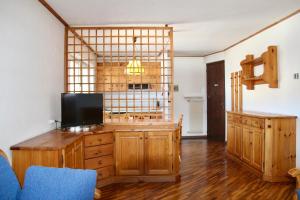 - un salon avec une télévision et un grand miroir dans l'établissement Residence Casa Cavalese, à Cavalese
