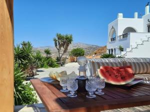 un tavolo con una bevanda e una fetta di anguria di Janakos Luxury Apartment a Glinado Naxos