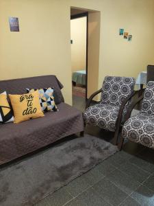 Habitación con cama, silla y espejo. en Casa em Campos do Jordão, en Campos do Jordão