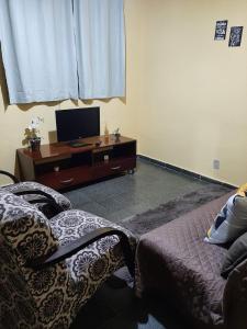 sala de estar con 2 camas y TV en Casa em Campos do Jordão, en Campos do Jordão