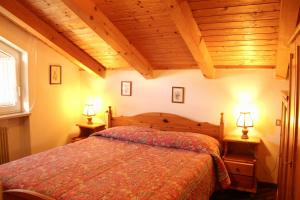 - une chambre avec un lit et deux lampes sur les tables dans l'établissement Residence Casa Cavalese, à Cavalese