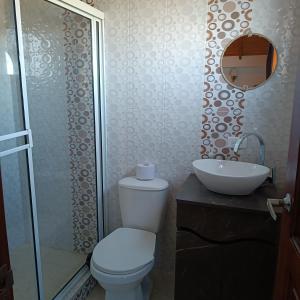 y baño con aseo y lavamanos. en Cabaña Villa Graciela, en Paipa